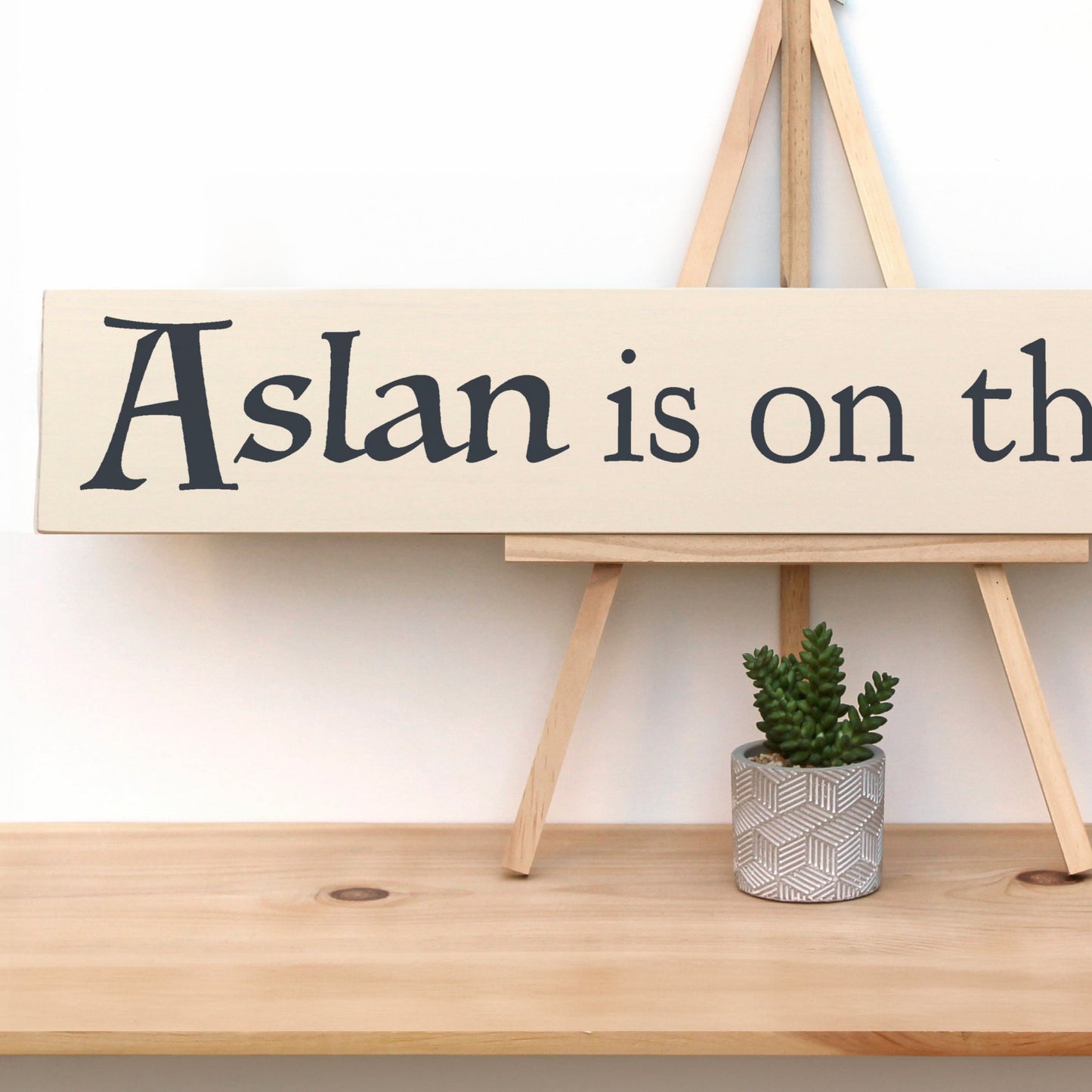 Wooden sign with text that reads, "Aslan is on the MOVE." The perfect Narnia themed wall decor.