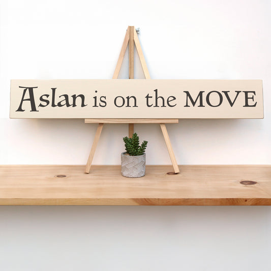 Wooden sign with text that reads, "Aslan is on the MOVE."  The perfect Narnia themed wall decor.