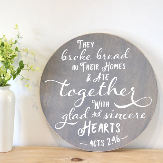 They broke bread in their homes and ate together with glad and sincere hearts.  Acts 2:46 Round Wooden Scripture Sign